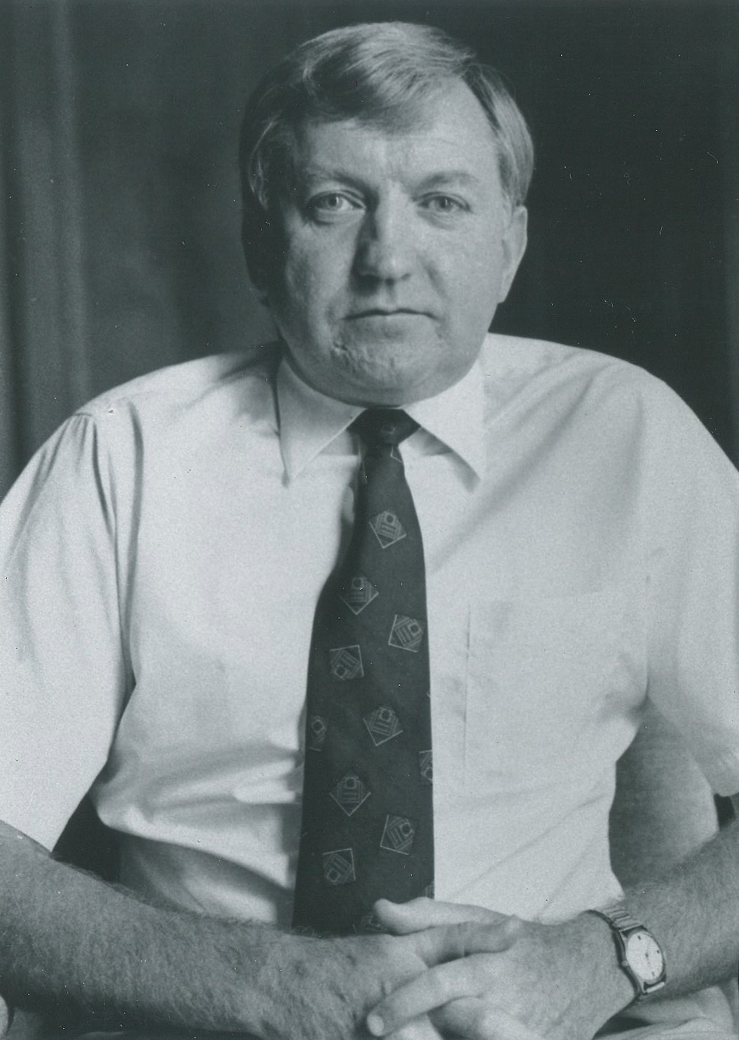 A portrait photo of Peter Lamb, former CIMMS director, sitting upright, hands crossed, looking peacefully at the camera. Photo taken in 1991.