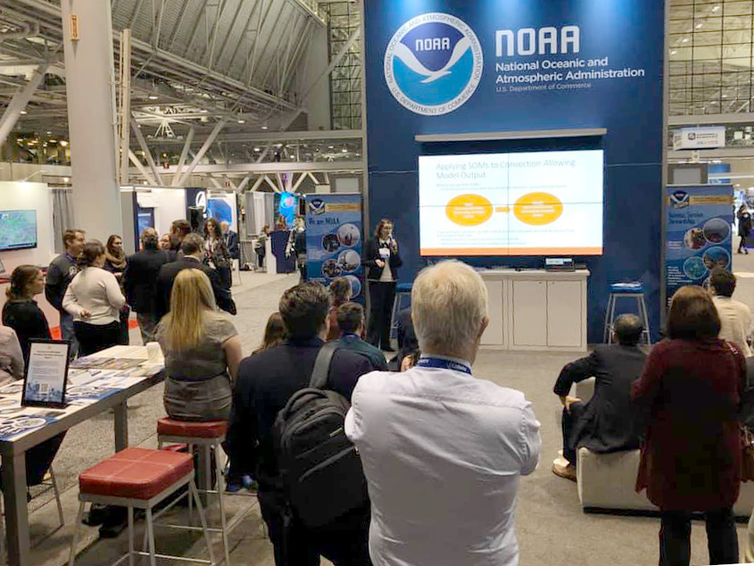 Burkely Gallo presenting on her and the teams machine learning techniques research at the NOAA booth at the American Meteorological Society 100th Annual Meeting in January 2020. Burkely is a University of Oklahoma Cooperative Institute for Mesoscale Meteorological Studies research whose work supports the NOAA NWS Storm Prediction Center. (Photo by Emily Summars-Jeffries/OU CIMMS/NOAA NSSL) | The OAR/NWS Shark Tank