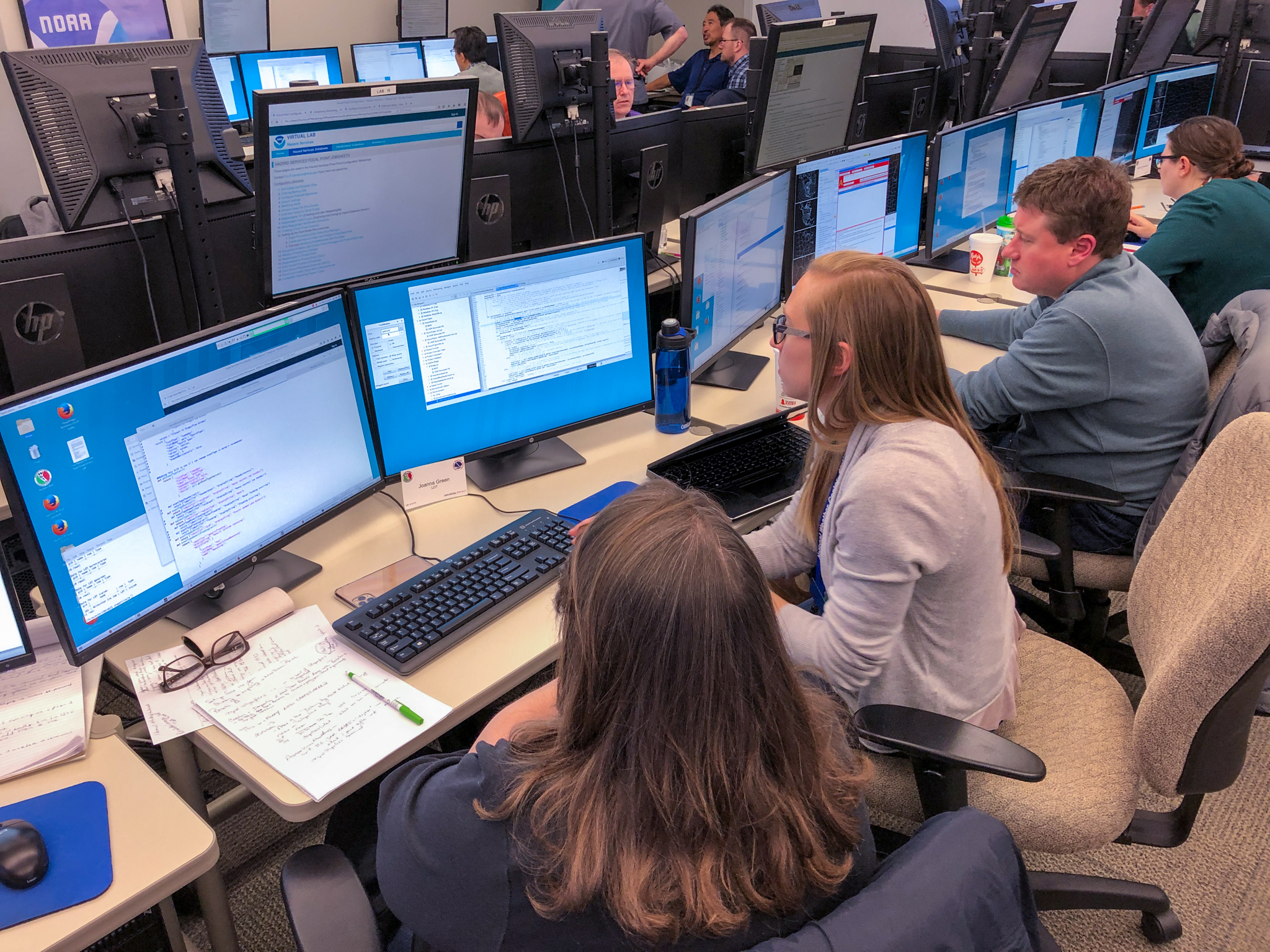 Sarah Borg working with a NWS forecaster on some coding issues. (Photo by Emily Summars-Jeffries/OU CIMMS)