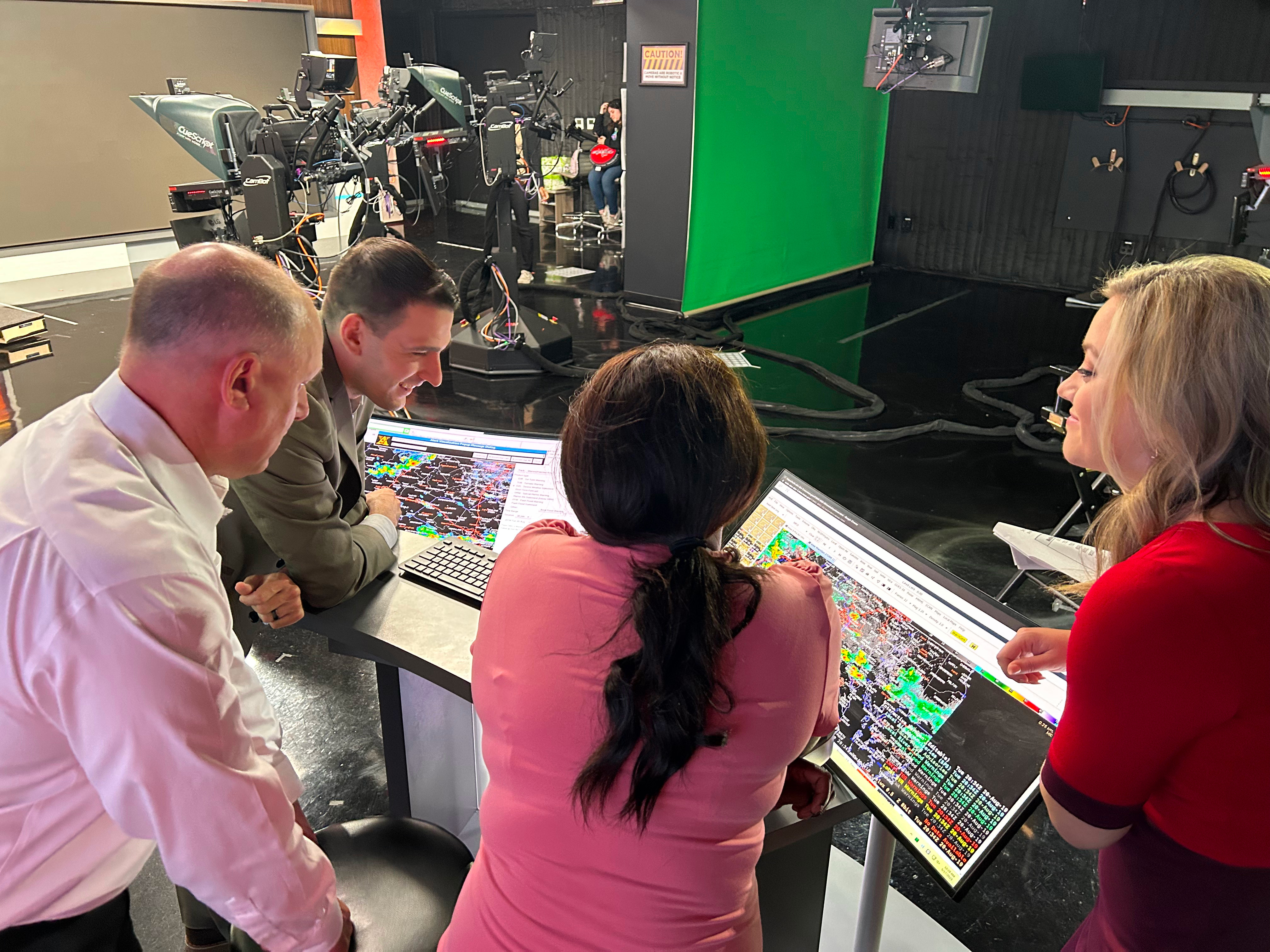 DC News Now Meteorologists Jackie Layer, Brittany Ward and Scott Sumner look on while NWS Meteorologist Erik Taylor talks about the typical visual setup for warning operations and the products used in making a warning decision.